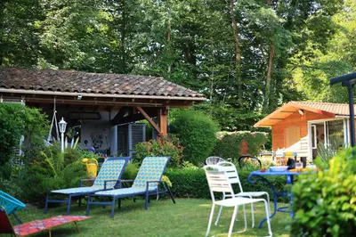 a group of chairs and a table in a yard at Chambre d'hôtes cosy Le Chalet -Tarn in Lacrouzette