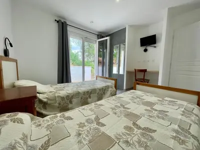 a hotel room with two beds and a window at Le Fenouillet Cottage proche des Grands Buffets in Narbonne