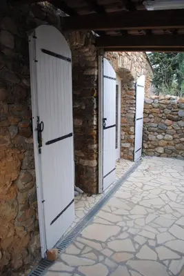 a row of white doors on a stone building at Le Fenouillet Cottage proche des Grands Buffets in Narbonne