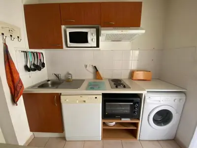 a small kitchen with a sink and a washing machine at Les Capucins in Carcassonne
