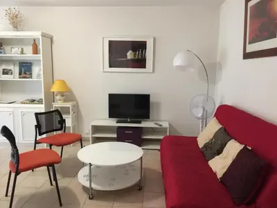 a living room with a red couch and a tv at Les Capucins in Carcassonne