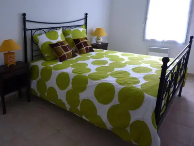 a bedroom with a green and white bed with pillows at Les Capucins in Carcassonne