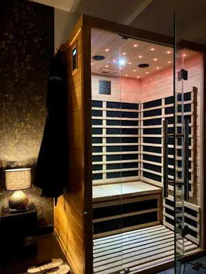 a walk in shower with a bench in a room at Love Room L'instanté - Suite 
