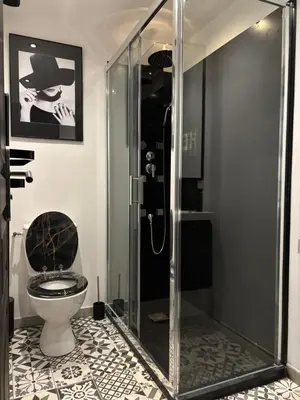 a bathroom with a toilet and a glass shower at Love Room L'instanté - Suite 