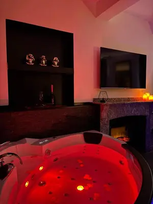 a red tub in a room with a fireplace at Love Room L'instanté - Suite 