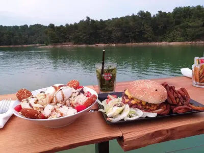 a table with a sandwich and a bowl of food and a drink at Charmant Studio proche Lac et Forêt in Carcassonne