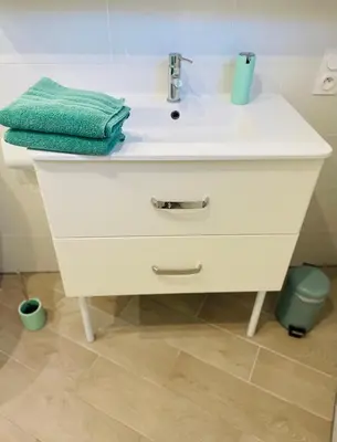 a white bathroom sink with a green towel on it at Charmant Studio proche Lac et Forêt in Carcassonne