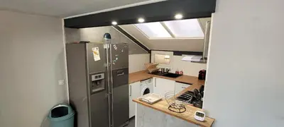 a small kitchen with a stainless steel refrigerator at Maison 3 pièces 5-7pers Vue sur port, garage, clim in Gruissan