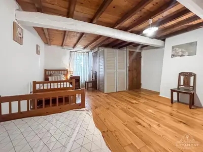 a bedroom with a bed and a wooden floor at Jardin Verdoyant à Soupex 