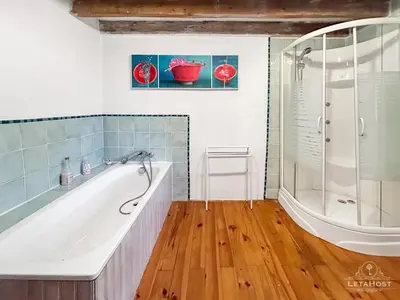 a bathroom with a tub and a shower at Jardin Verdoyant à Soupex 