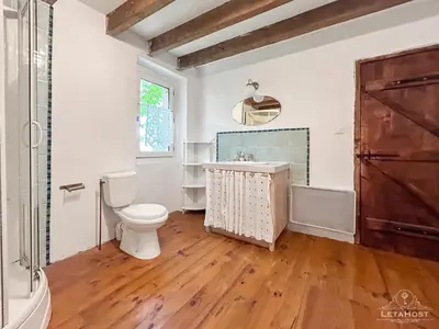 a bathroom with a toilet and a sink and a window at Jardin Verdoyant à Soupex 