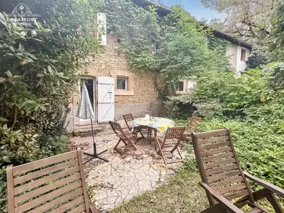 a patio with a table and chairs in front of a building at Jardin Verdoyant à Soupex 