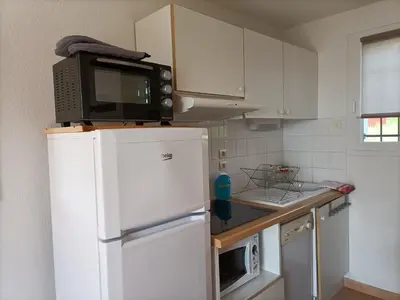 a kitchen with a microwave on top of a refrigerator at Gîte du Gua des Brasses au bord du lac de la Raviège in La Salvetat