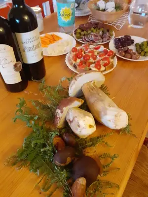 a wooden table with bottles of wine and plates of food at Gîte du Gua des Brasses au bord du lac de la Raviège in La Salvetat
