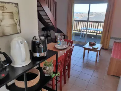 a kitchen and dining room with a table and chairs at Gîte du Gua des Brasses au bord du lac de la Raviège in La Salvetat