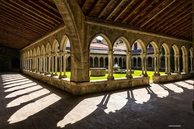 a building with columns and arched windows and shadows at Gite Joséphine dans une tour médiévale - Carcassonne in Saint-Hilaire