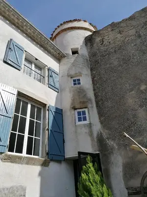 a building with blue doors and windows on it at Gite Joséphine dans une tour médiévale - Carcassonne in Saint-Hilaire