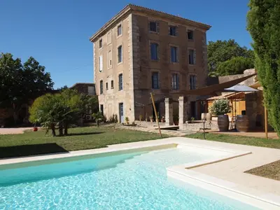 a large swimming pool in front of a building at Gites de l'écluse - La Côte de l'Or in Sallèles-dʼAude