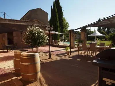 a patio with a table and chairs and a barrel at Gites de l'écluse - La Côte de l'Or in Sallèles-dʼAude