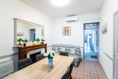 a living room with a table and a couch at Appartement Les Halles , Climatisation, Terrasse, Garage in Narbonne