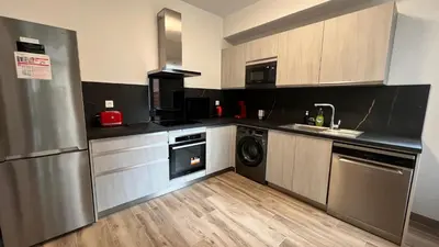 a kitchen with a stainless steel refrigerator and a dishwasher at Appartement Les Halles , Climatisation, Terrasse, Garage in Narbonne