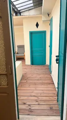 a hallway with a green door in a room at Appartement Les Halles , Climatisation, Terrasse, Garage in Narbonne