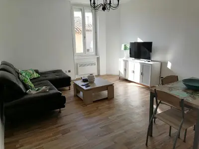 a living room with a couch and a table and a tv at T3 proche de la mer in Portel-des-Corbières