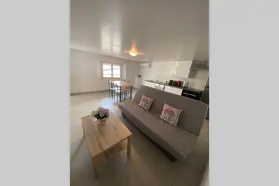 a living room with a couch and a table at Koh Samet Siam Manahakhon Appart & Spa in Rieux-de-Pelleport