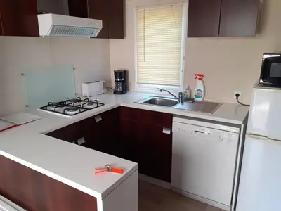 a kitchen with a sink and a stove top oven at MOBILHOME agréable sans draps ni serviettes in Port-la-Nouvelle