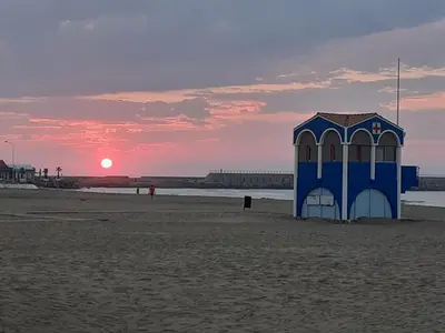 a blue lifeguard shack on the beach at sunset at MOBILHOME agréable sans draps ni serviettes in Port-la-Nouvelle