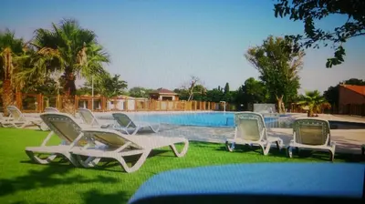 a group of lounge chairs and a swimming pool at MOBILHOME agréable sans draps ni serviettes in Port-la-Nouvelle