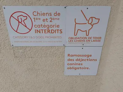 two signs on a wall with a dog on it at MOBILHOME agréable sans draps ni serviettes in Port-la-Nouvelle
