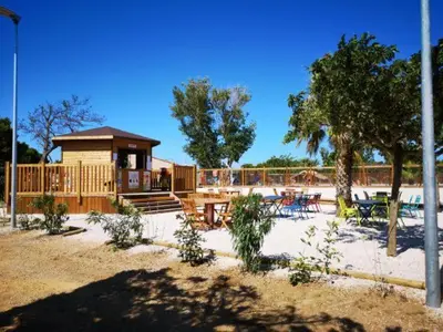 a pavilion with tables and chairs in a park at Le Solèou in Port-la-Nouvelle
