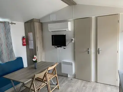 a room with a table and chairs and a tv at Le Solèou in Port-la-Nouvelle
