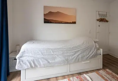 a white bed in a bedroom with a picture on the wall at Horizons Verts Appartement Cerisier in Puivert