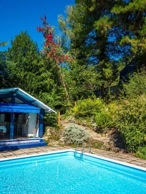 a swimming pool next to a house with trees at Horizons Verts Appartement Cerisier in Puivert
