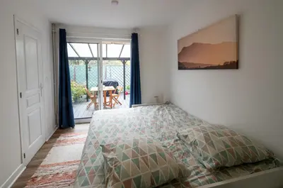 a bedroom with a bed and a door to a patio at Horizons Verts Appartement Cerisier in Puivert