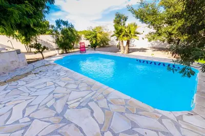 a swimming pool with blue water in a yard at Villa Napoléon Piscine&Jacuzzi in Le Somail