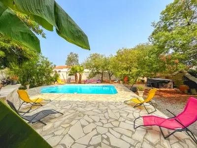 a swimming pool with four chairs and a swimming pool at Villa Napoléon Piscine&Jacuzzi in Le Somail