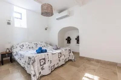 a bedroom with a bed in a white room at Villa Napoléon Piscine&Jacuzzi in Le Somail