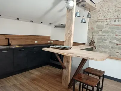 a kitchen with a wooden table in a room at Une perle dans la malepère. in Montréal