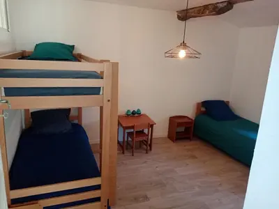 a room with two bunk beds and a table at Une perle dans la malepère. in Montréal
