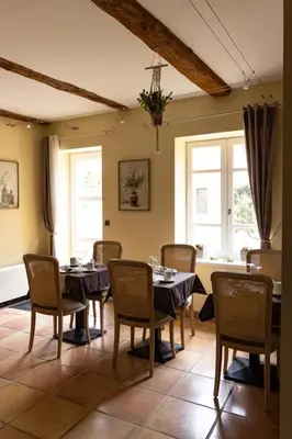 a dining room with tables and chairs and windows at Chambres d'hôtes Château de Jonquières in Narbonne