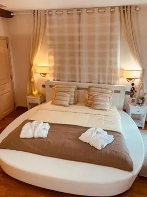 a bedroom with a large bed with two towels at Chambres d'hôtes Château de Jonquières in Narbonne