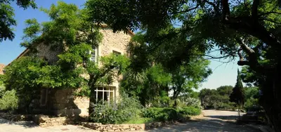 an old stone house with trees in front of it at Chambres d'hôtes Château de Jonquières in Narbonne