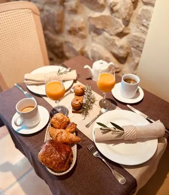 a table with breakfast foods and coffee and orange juice at Chambres d'hôtes Château de Jonquières in Narbonne