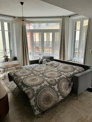 a large bed in a room with windows at 102 - Cheminée de la Bastide in Carcassonne