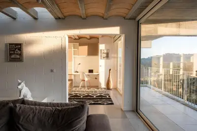 a living room with a couch and a balcony at Villa des Cathares in Carcassonne