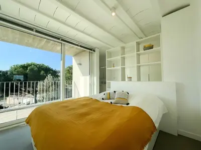 a bedroom with a bed and a large window at Villa des Cathares in Carcassonne