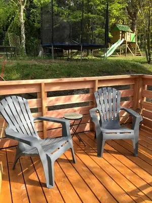 two chairs and a table on a deck with a playground at Fanjeaux Aude Le Chalet in Fanjeaux